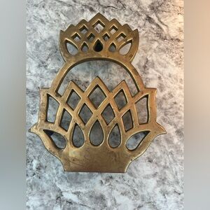 A vintage brass pineapple-shaped trivet by Virginia Metalcrafters.